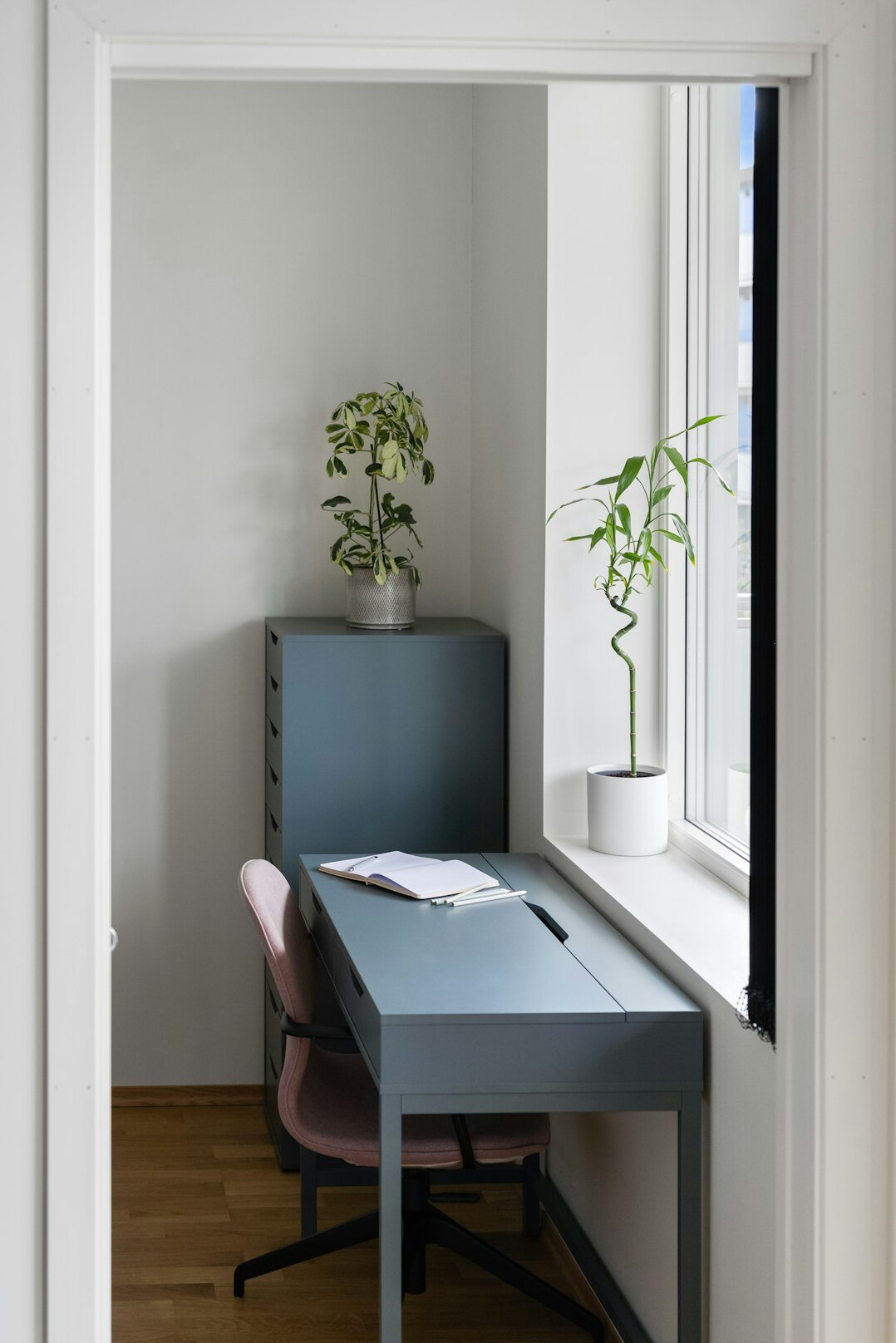 Small modern office desk with a laptop and notebook