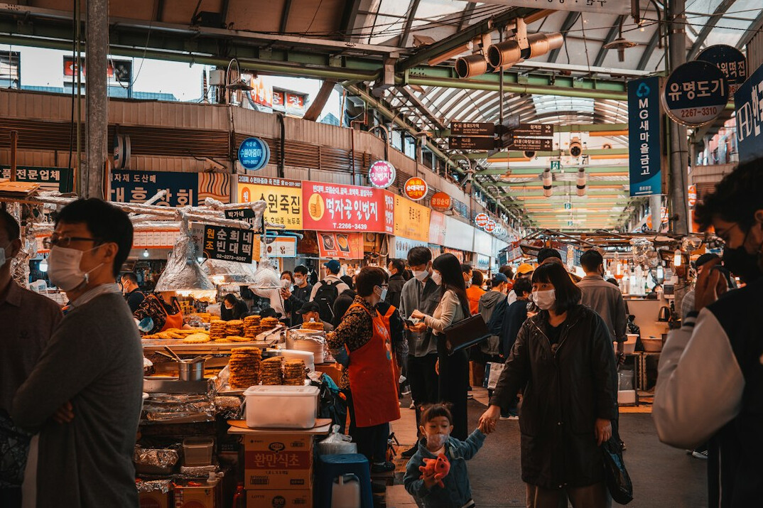 Long queue of people waiting at an outdoor Danish food market